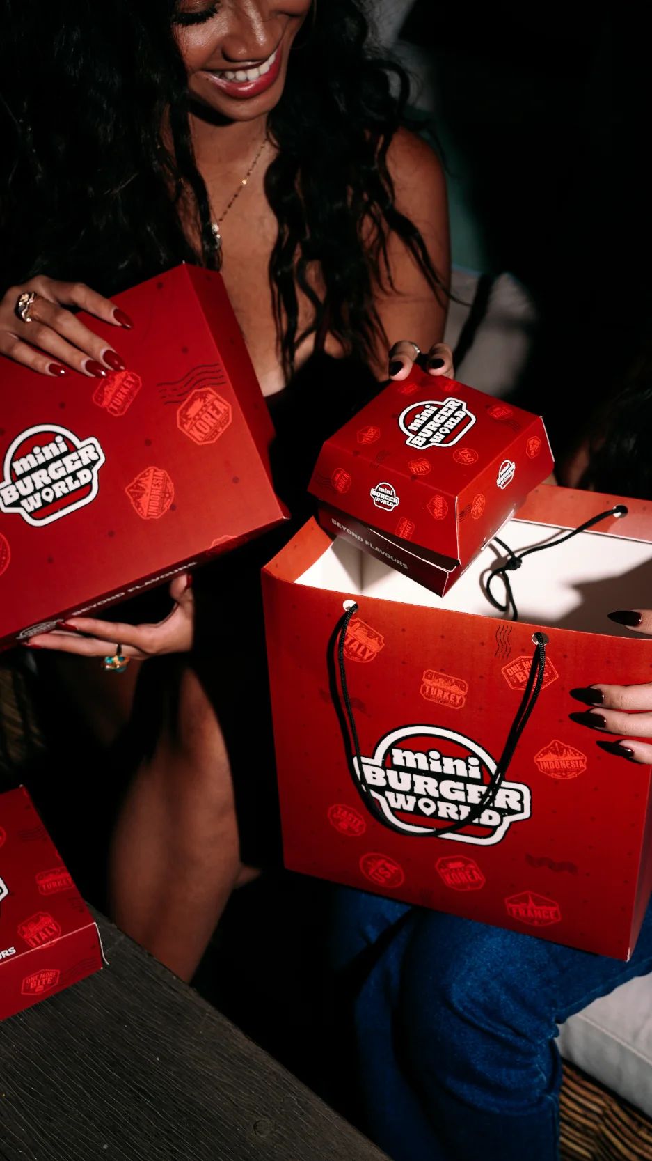 A guest unpacking Mini Burger World boxes and a gift bag